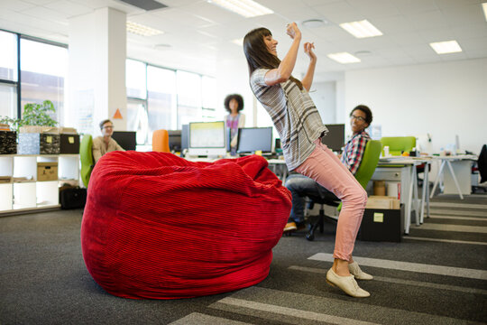 Businesswoman playing in beanbag chair in office