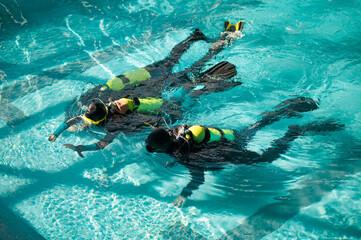 Divemaster and divers in aqualungs, dive course