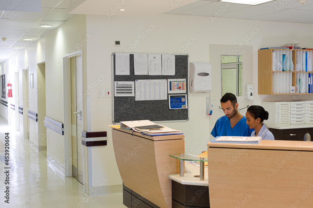 Wall mural nurse and doctor talking in hospital reception