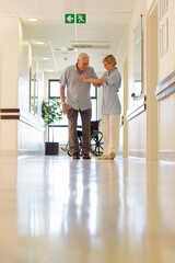 Older patient and nurse standing in hospital