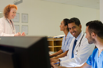 Hospital staff talking at front desk