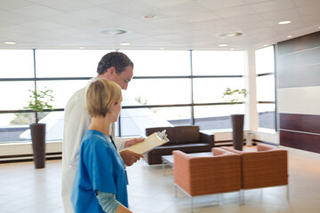 Doctor and nurse talking in hospital hallway