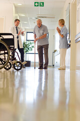 Doctor and nurse talking to patient in hospital room