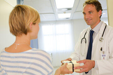 Obraz premium Patient giving doctor gift in hospital