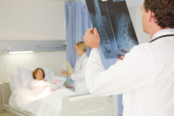 Doctors examining x-rays in hospital room