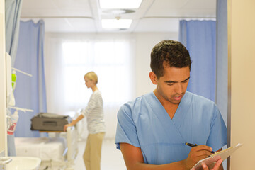 Doctor writing on clipboard in hospital