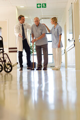 Fototapeta premium Doctor and nurse talking to patient in hospital room