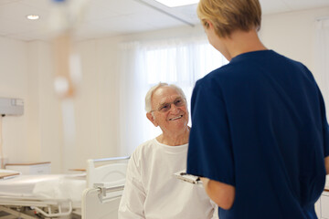 Obraz premium Nurse and older patient talking in hospital room