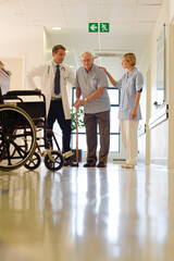 Doctor and nurse talking to patient in hospital room