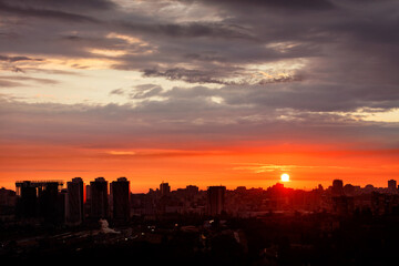 Night city silhouettes, morning city summer landscape against the backdrop of a bright orange...