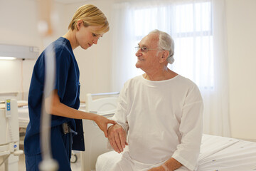 Fototapeta premium Nurse and older patient talking in hospital room