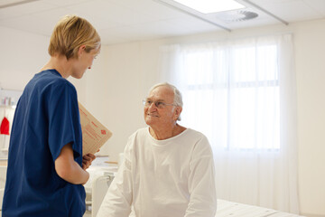 Fototapeta premium Nurse talking with older patient in hospital