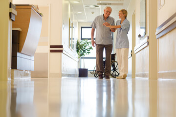 Older patient and nurse standing in hospital
