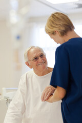 Obraz premium Nurse reading older patient's medical bracelet in hospital