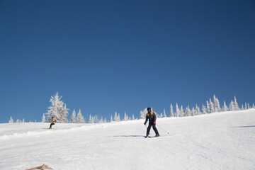 The ski slopes of the resort. Skiers and snowboarders on the slope of the ski resort