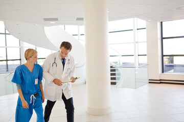 Doctor and nurse talking in hospital hallway