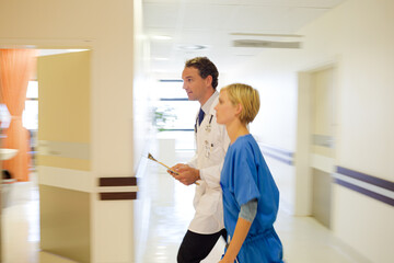 Nurse and doctor walking in hospital hallway