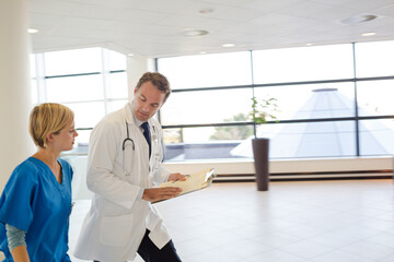 Naklejka na ściany i meble Doctor and nurse talking in hospital hallway