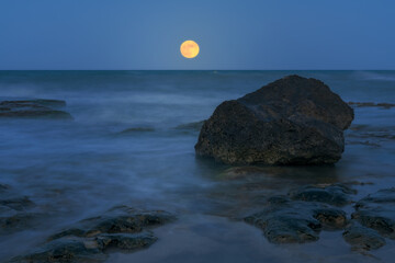 Fine art image of a rock and the full moon in Cervera Cape in Torrevieja