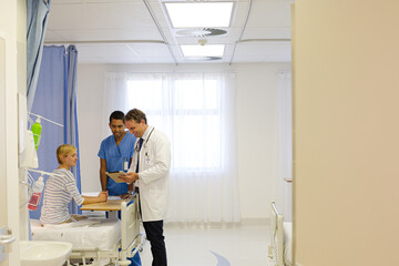 Doctor and nurse talking to patient in hospital room