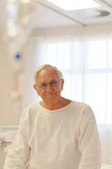 Older patient wearing gown in hospital room