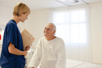 Obraz premium Nurse talking with older patient in hospital