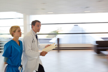 Fototapeta premium Doctor and nurse talking in hospital hallway