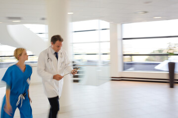 Doctor and nurse talking in hospital hallway