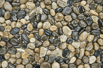 Texture of smooth stones decoratively laid out on the ground. Landscape design fragment.