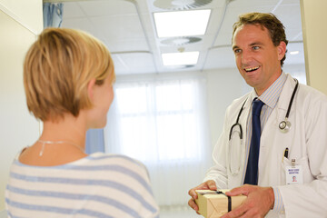 Obraz premium Patient giving doctor gift in hospital