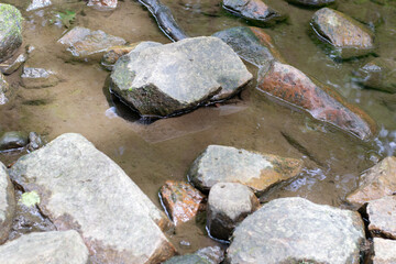 Fototapeta na wymiar River water running around rocks