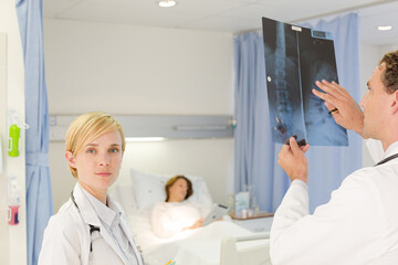 Obraz premium Doctors examining x-rays in hospital room