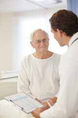 Doctor talking to older patient in hospital