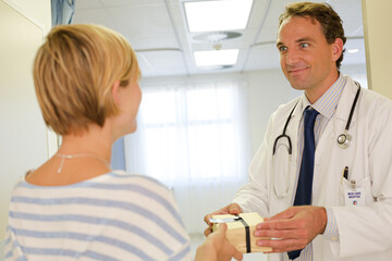 Obraz premium Patient giving doctor gift in hospital
