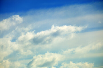 Naklejka na ściany i meble Blue sky background with blurred soft clouds