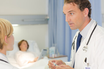 Doctor checking syringe in hospital room