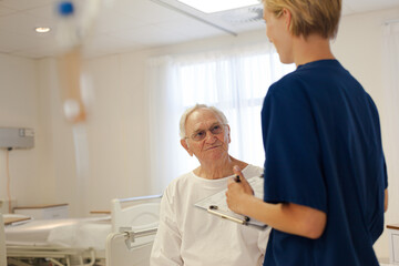 Obraz premium Nurse and older patient talking in hospital room