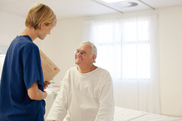 Nurse talking with older patient in hospital