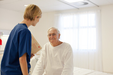 Obraz premium Nurse talking with older patient in hospital