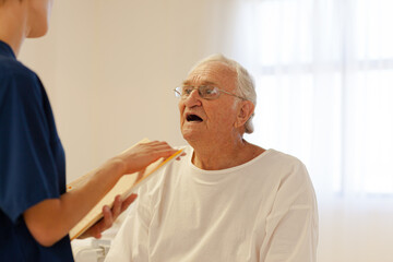 Nurse talking with older patient in hospital