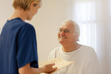 Nurse talking with older patient in hospital