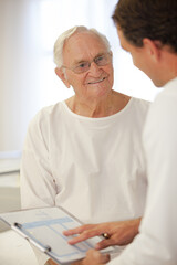 Doctor talking to older patient in hospital