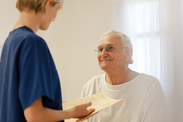 Obraz premium Nurse talking with older patient in hospital