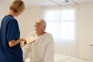 Obraz premium Nurse talking with older patient in hospital