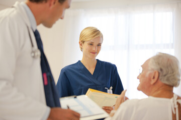 Fototapeta premium Nurse and doctor talking with older patient in hospital