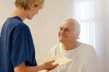 Obraz premium Nurse talking with older patient in hospital