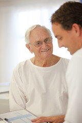 Doctor talking to older patient in hospital