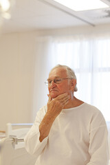 Fototapeta premium Older patient wearing gown in hospital room