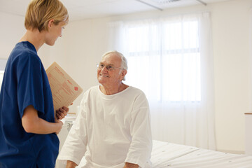 Nurse talking with older patient in hospital