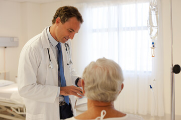 Fototapeta premium Doctor talking with patient in hospital room